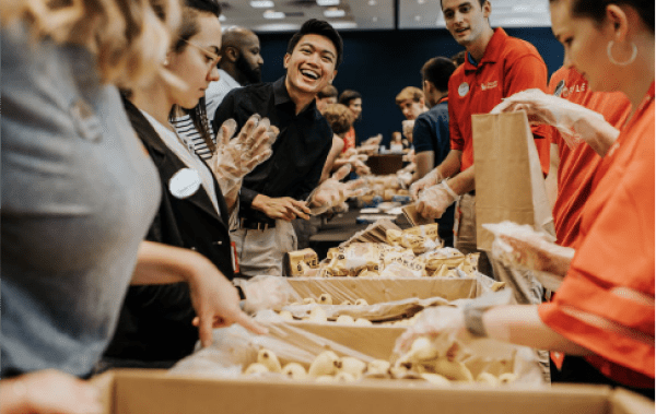Group of Chick-fil-A® employees packing meals in bags