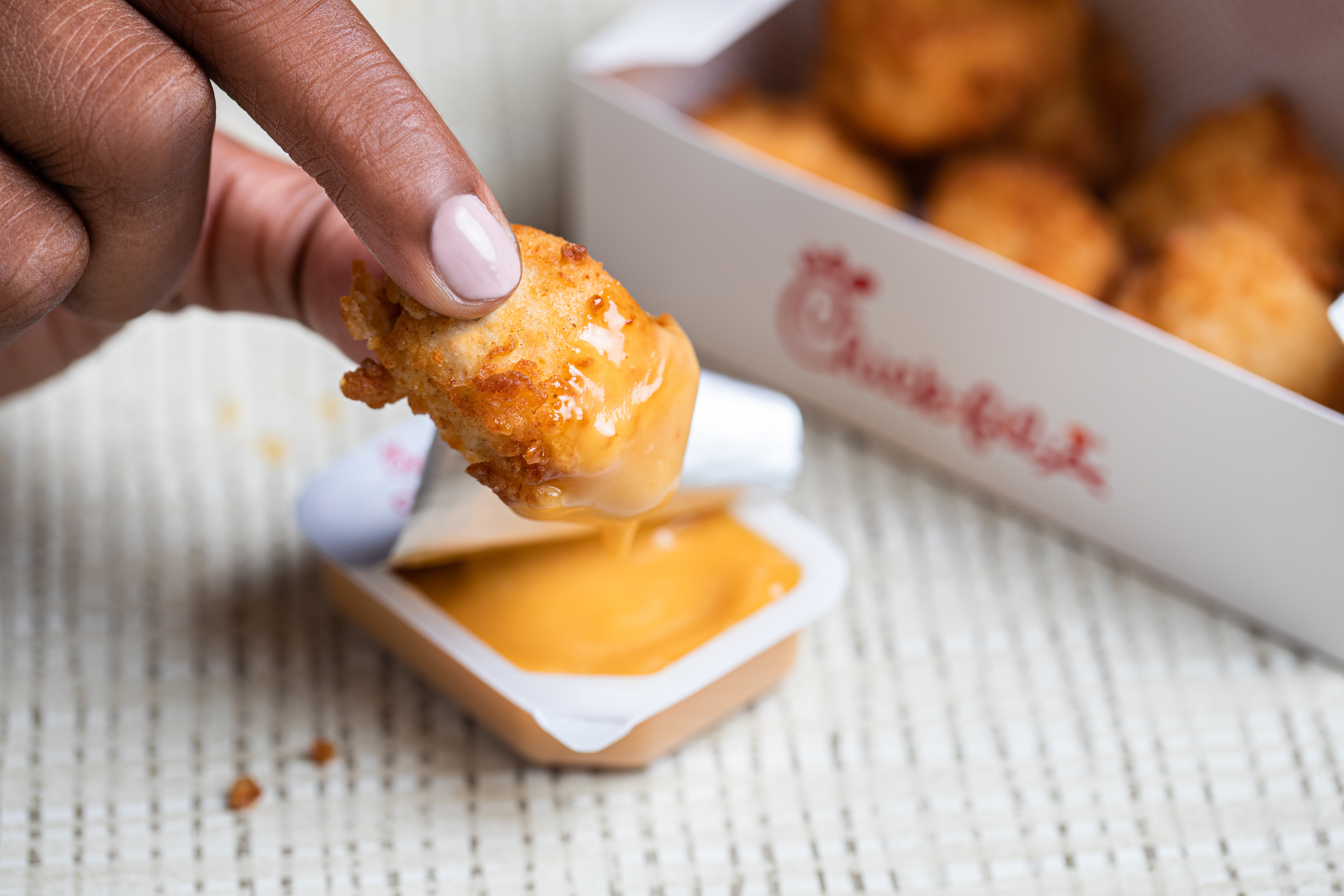 Close-up of Chick-fil-A® Nuggets dipped into Chick-fil-A sauce