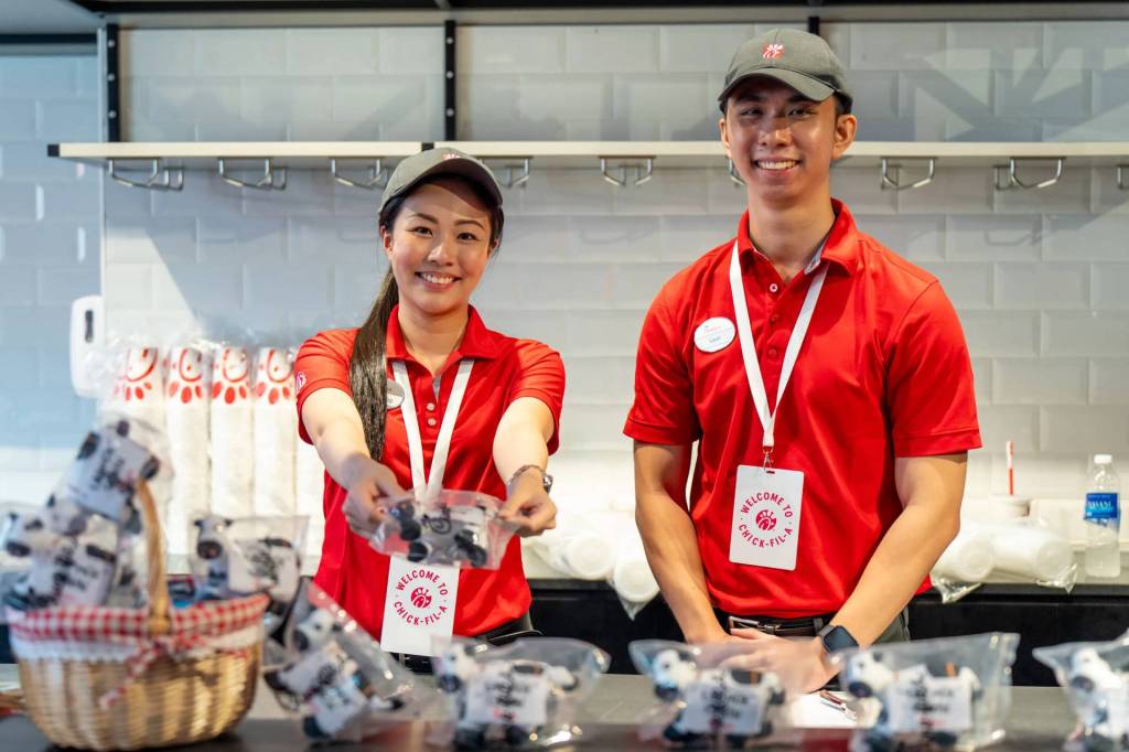 Two team member smiling in Chick-fil-A uniforms.